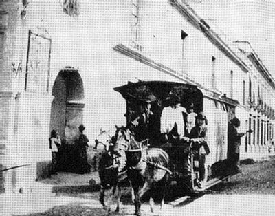Foto del tranvía tirado por caballos, sobre calle empedrada llamada Caridad Angosta.